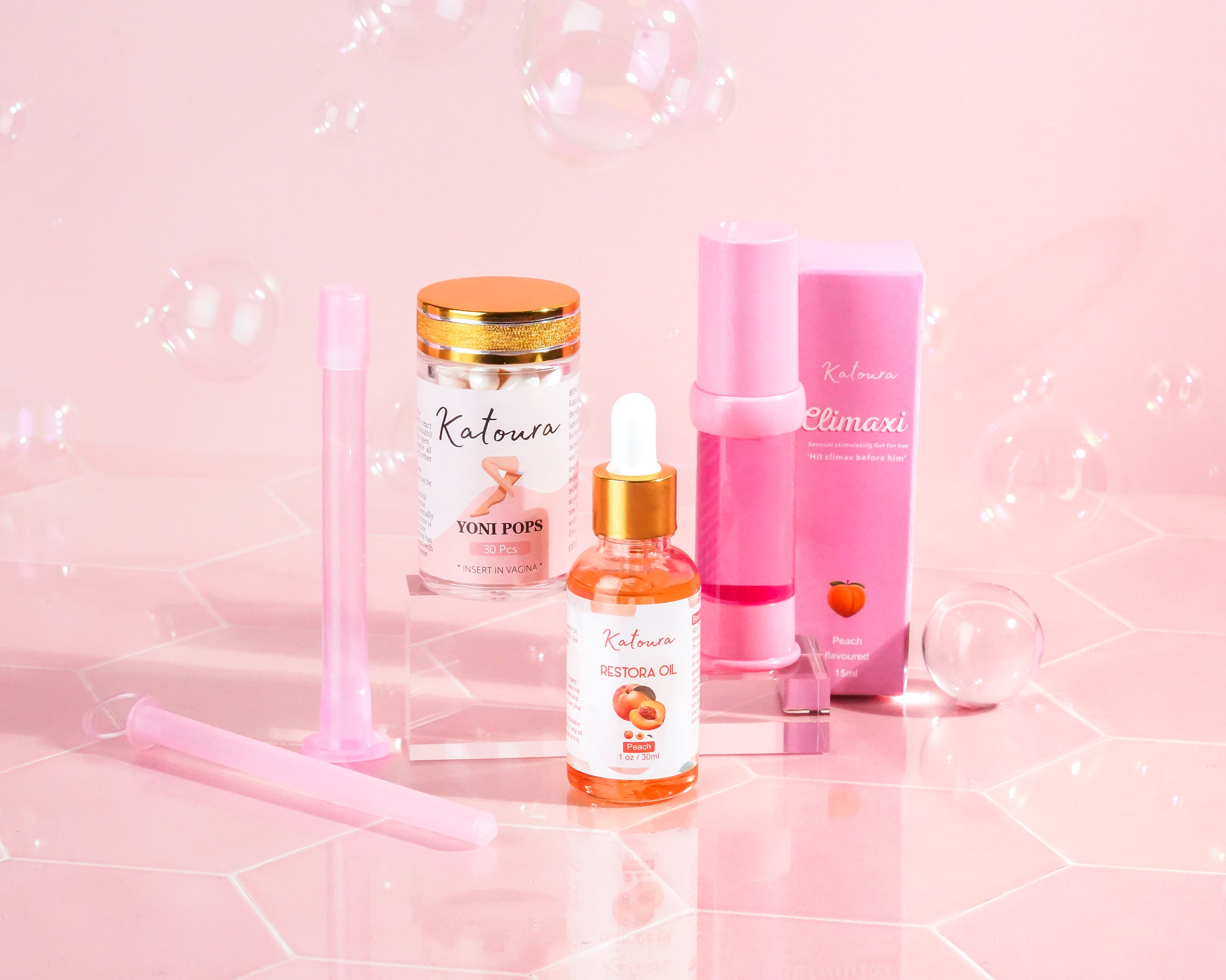 Assorted cosmetic products on a pink background with bubbles.